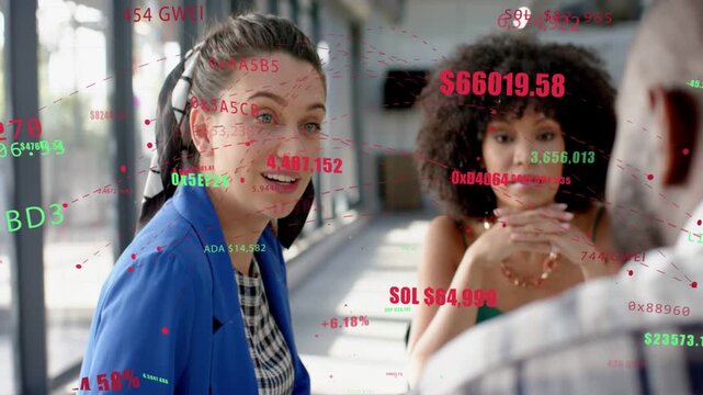 Man speaking behind, two women leaning and discussing market with crypto tickers floating