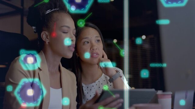 Right woman pointing left using tablet light band shifting AR aligning tech for review on screen