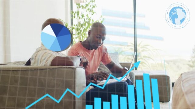 Father guiding while son typing on laptop, initiating animated finance charts analyzing data