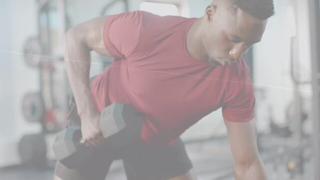 Vertical video: Gym trainee gripping hex dumbbell and bracing left, performing rows for muscle gain