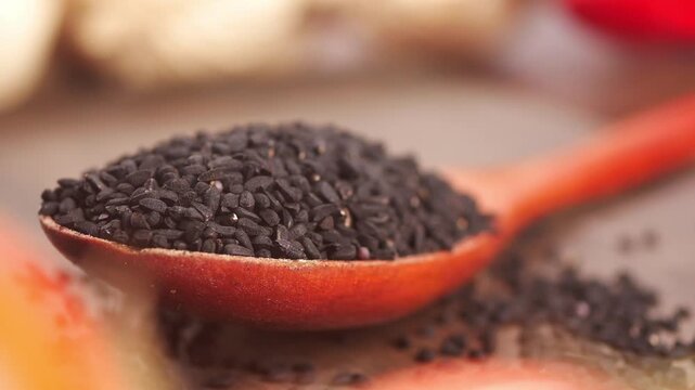 Black cumin seeds on a wooden spoon ready for use