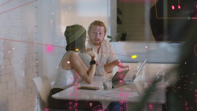 Seated duo pointing at laptop, team coming, handing tablet, docs, sparking IT review under pink HUD