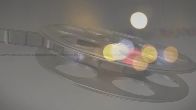 On play metal film reel tilting and rotating while colored bokeh shifting for cinematic overlay
