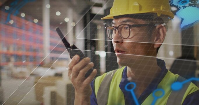 Holding radio, Korean worker in hard hat and hi-vis vest surveying racks, AR graphics, copy space
