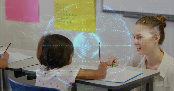 Guiding teacher leaning over polka-dot student writing book in class, holding green item blue globe