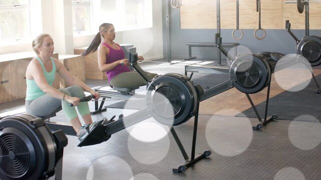 Camera focusing on right rower, two rowers rowing and syncing for fitness, bokeh overlaying