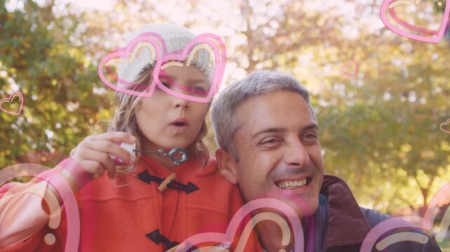 Child blowing bubble wand dad smiling pink hearts sweeping across bubbles for family content