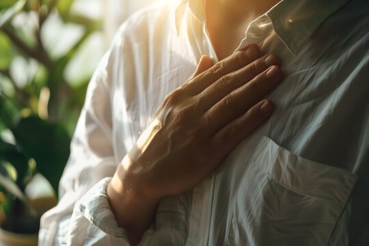 Person legt Hand auf die Brust als Zeichen von Achtsamkeit und innerer Ruhe
