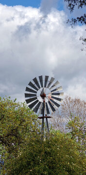 Rural farm windmill under sky clouds