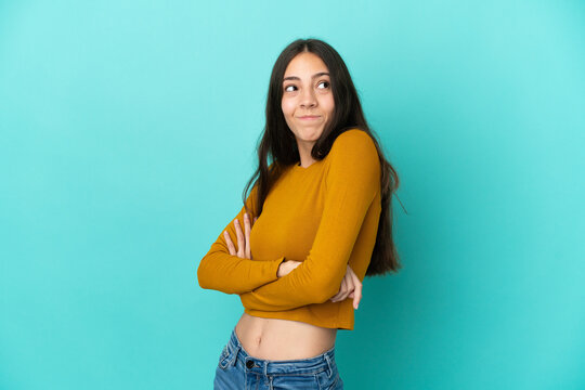 Young French woman isolated on blue background making doubts gesture while lifting the shoulders