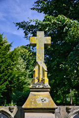 sehr großer alter Grabstein mit einem Steinkreuz auf einem Friedhof in Köln © Blende8