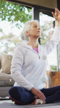 Vertical video: Senior woman starting arm lift, stretching right side for health with icons guiding
