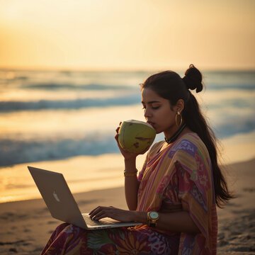  Young Woman Working Remotely on a Beach in Sri Lanka at Sunset.A lifestyle shot of a young freelancer working on a laptop from a beachside caba