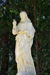 Große Jesusstatue mit Friedenzeichen auf einem Friedhof in Köln © Blende8