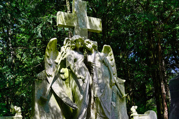 zwei Engel unter einem Steinkreuz auf einem Friedhof in Köln  © Blende8