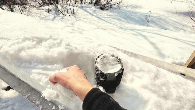 Snowy Winter Moment. Casual Hobbyist Gathers Snow From Icy Backyard Railing In Sunlight. Person Casually Collects Snow From Snowcovered Railing During Bright Winter Day In Backyard