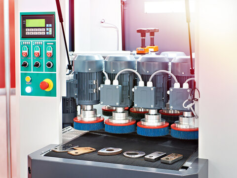 Industrial deburring and polishing machine with rotating brushes in factory