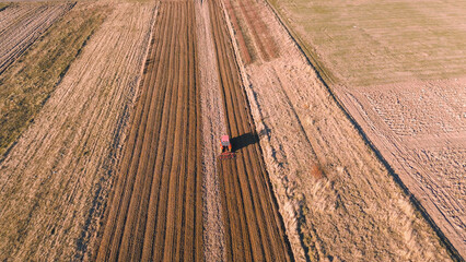 Top-down view of ploughing tractor on farmland © AlexGo