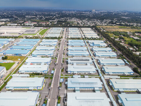 Aerial view of a large industrial park with blue-roofed warehouses and factories organized in a grid layout in An Phuoc, Dong Nai, Vietnam.