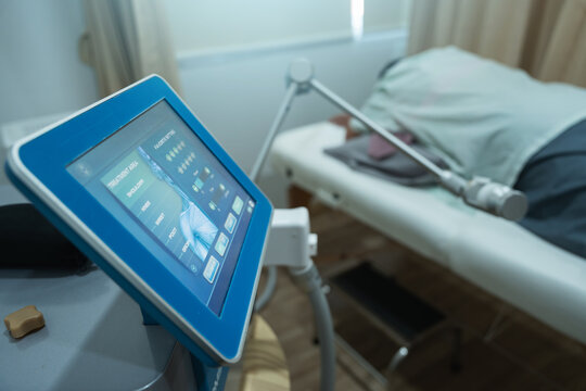 Physical therapy pms device peripheral magnetic stimulation treatment machine near patient bed in clinic room calm atmosphere enhancing recovery and comfort for leg pain relief