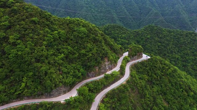 Car Driving Along a Winding Mountain Road Through Scenic Highland Landscape