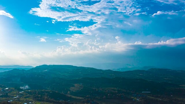 Aerial Time Lapse of Rolling Cloud Sea Above Mountains Under Clear Blue Sky