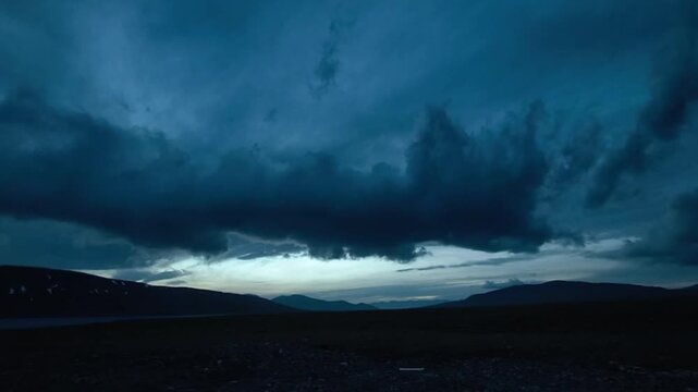 Heavy dark storm clouds moving across the sky at sunset over the vast mountain plateau in Tibet China.