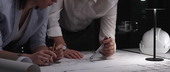 Professional business team reviewing building plans together. Architects and engineers collaborating on new construction project. Concept of cooperation, planning and corporate workflow © volha_r