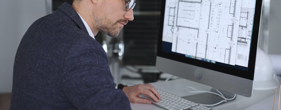 Architect developing building blueprint on computer, engineering and urban planning a new construction project. Business and architecture concept