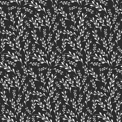 A beautiful seamless pattern features numerous white branches with small leaves, arranged densely on a dark background. © okskukuruza