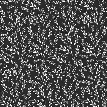 A beautiful seamless pattern features numerous white branches with small leaves, arranged densely on a dark background.