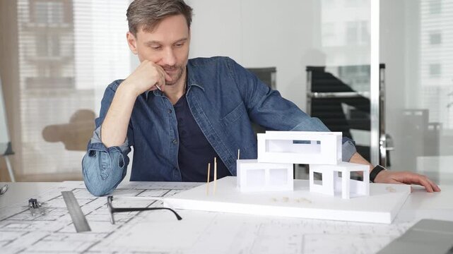 Stressed architect feeling overwhelmed and frustrated, suffering from burnout while working on blueprints for a tight project deadline in a modern office setup