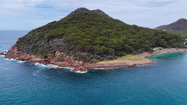 Aerial drone video panning around World War II torpedo and gun emplacements at Tomaree Head in Port Stephens, New South Wales, Australia. Scenic coastal landscape featuring historic military structure