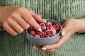 Frozen raspberries in bowl background. Healthy berry snack closeup. Woman hands holding fruit. Fresh nutrition concept. Red summer dessert ingredient. Clean lifestyle food smoothie preparation. © Paweł Michałowski