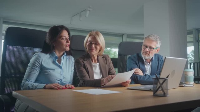 Mature businesswoman leading office training, teaching team AI software for business analytics and finance tools