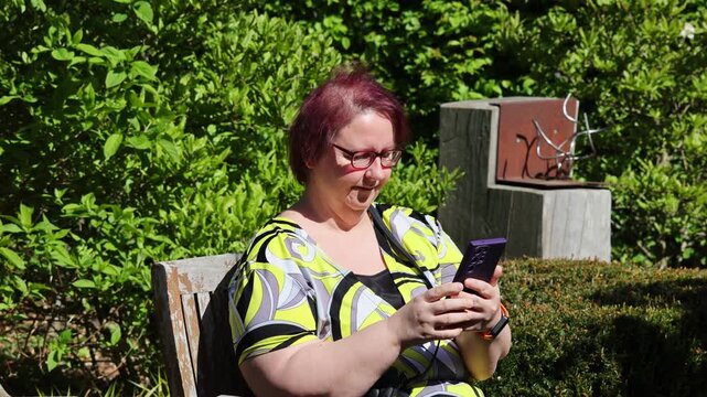 Woman sitting on a bench, reacting with a facepalm to content on her phone
