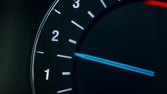 Close up of digital trip computer of modern car with illuminated needle showing engine RPM during vehicle driving