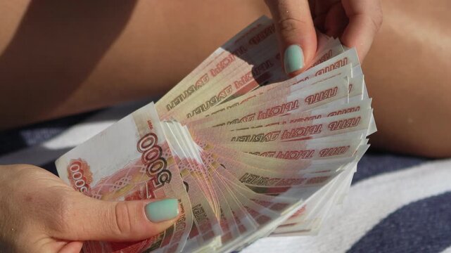 Money, Counting, Woman hands fan out Russian ruble banknotes, displaying wealth outdoors.