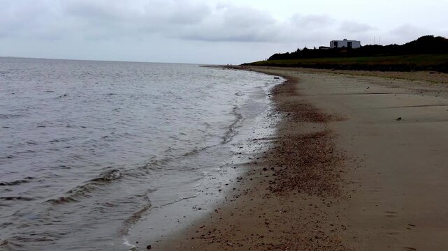 Sandy Beach with Gentle Waves Along Curved Shoreline Near Esbjerg, Denmark