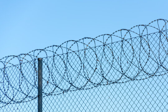 Close Up Razor Wire Security Fence With Blue Sky