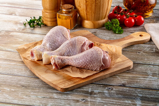 Fresh raw chicken drumstick over board