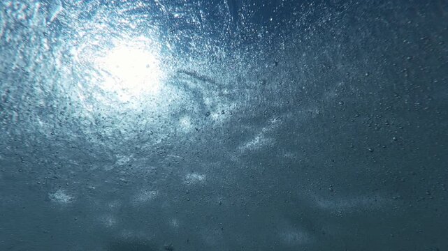 Time lapse: Thin translucent ice with frozen inside tiny air bubbles floats towards us, shimmering and sparkling under bright sunrays against backdrop of vibrant blue sky, backlighting by sun