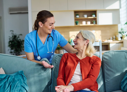 Portrait of a doctor or nurse woman caregiver supporting senior woman, hand on the shoulder care and hug at home or nursing home
