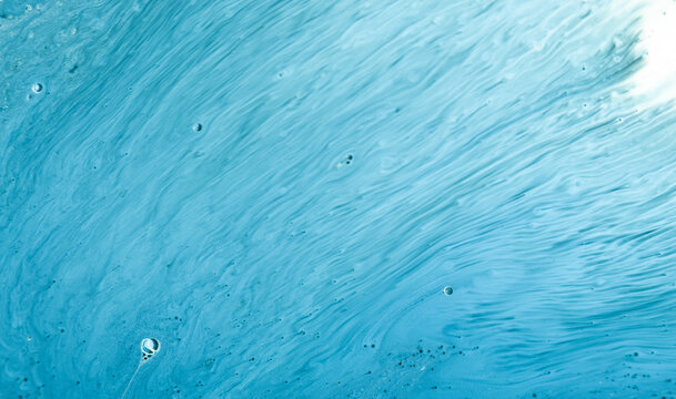Water with bubbles and flowing patterns captured close up in a light blue shade showing interesting textures