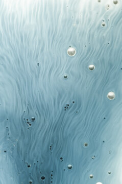 Water with bubbles and flowing patterns captured close up in a light blue shade showing interesting textures