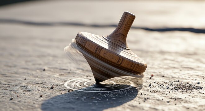 A classic wooden spinning top toy rotating on a textured stone surface with warm sunlight and depth of field