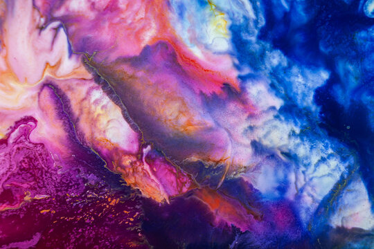 Colorful abstract art created with fluid paint techniques on a canvas during daylight