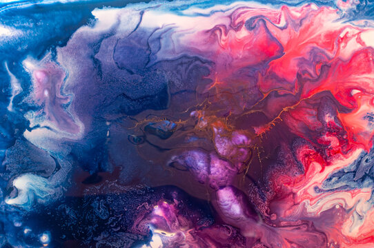 Colorful abstract art created with fluid paint techniques on a canvas during daylight