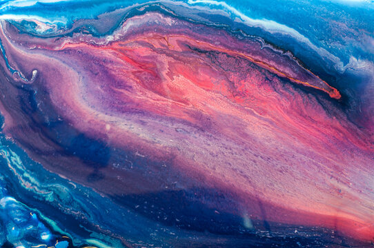 Colorful abstract art created with fluid paint techniques on a canvas during daylight