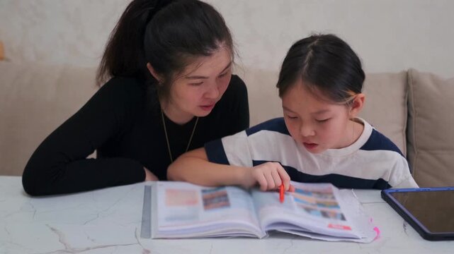 Young girl struggles with school homework while mother tries to help, signs of low performance and learning difficulties, stress and pressure during study, Kyrgyz Asian family at home